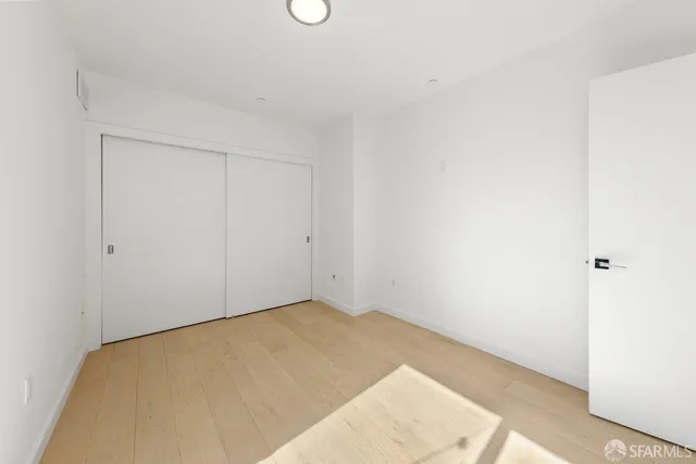 a kitchen with stainless steel appliances kitchen island granite countertop a refrigerator a stove a sink and a refrigerator with wooden floor