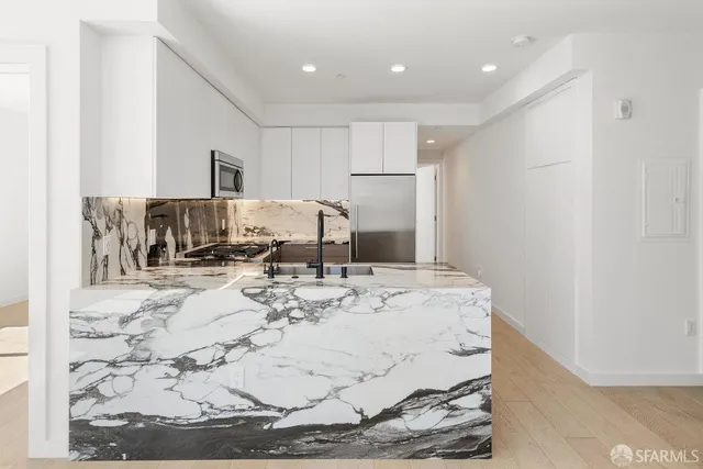 a kitchen with granite countertop a stove sink and refrigerator