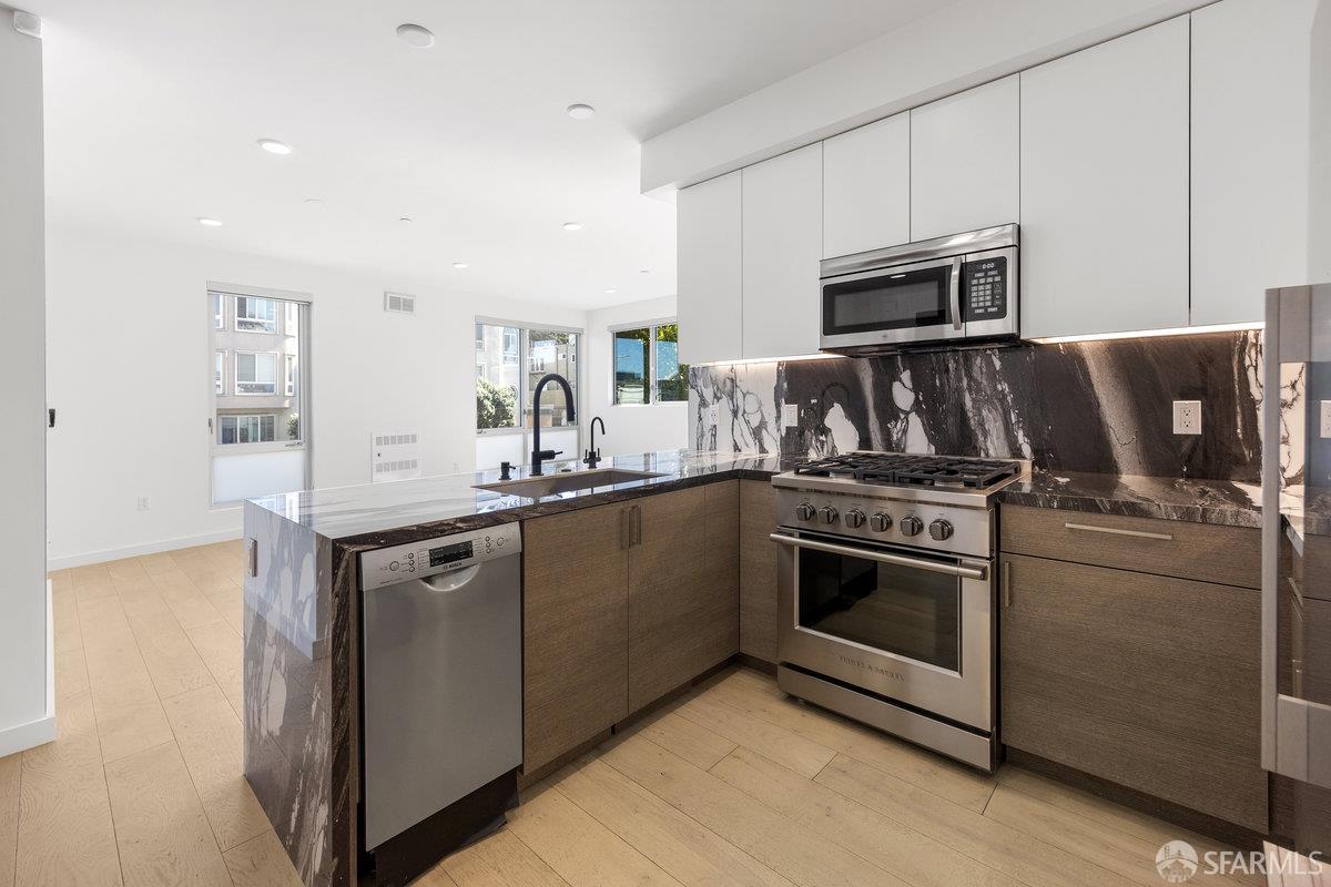 1 Stanyan Street, Unit 24 San Francisco, CA 94118 - Photo 26 of 51 a kitchen with kitchen island granite countertop a sink and stainless steel appliances