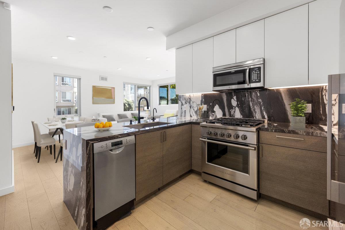 1 Stanyan Street, Unit 24 San Francisco, CA 94118 - Photo 7 of 51 a kitchen with kitchen island granite countertop a sink cabinets and stainless steel appliances