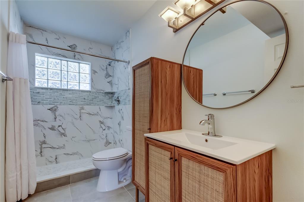 3936 East Eden Roc Circle Tampa, FL 33634 - Photo 30 of 68 a bathroom with a sink a toilet and shower