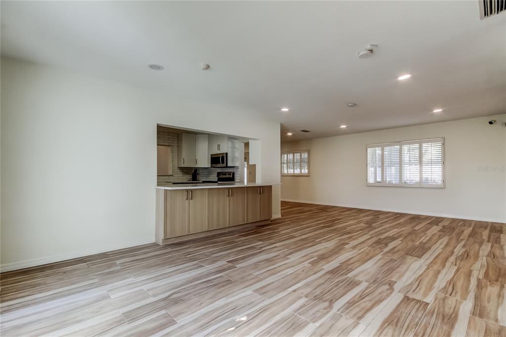 3936 East Eden Roc Circle Tampa, FL 33634 - Photo 3 of 68 a view of kitchen and empty room with wooden floor