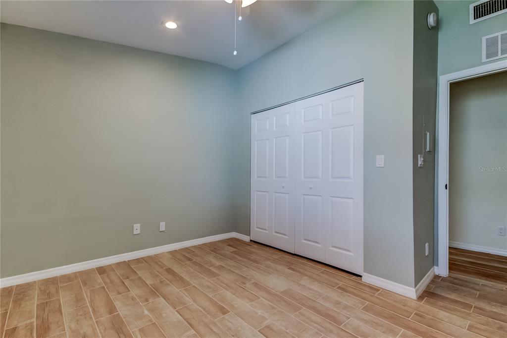 3936 East Eden Roc Circle Tampa, FL 33634 - Photo 43 of 68 an empty room with wooden floor and closet