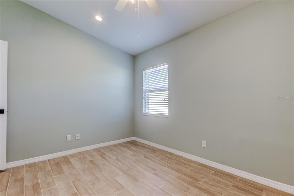 3936 East Eden Roc Circle Tampa, FL 33634 - Photo 45 of 68 an empty room with wooden floor and windows