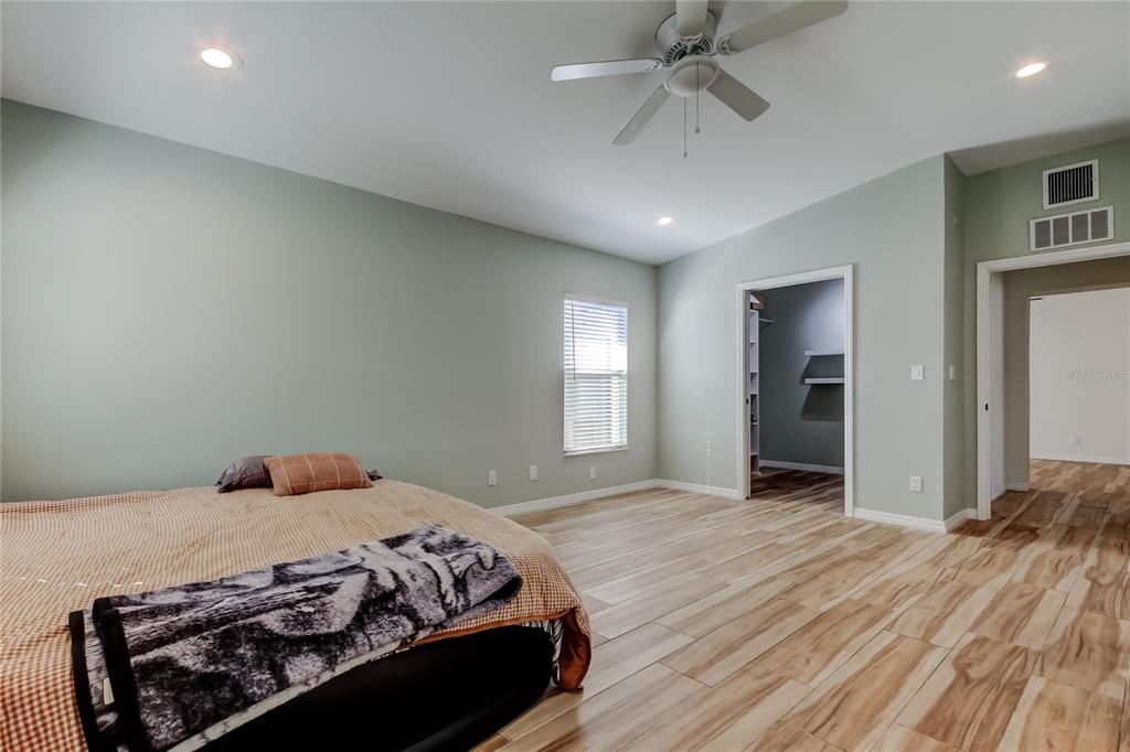 3936 East Eden Roc Circle Tampa, FL 33634 - Photo 48 of 68 a bedroom with a bed and a ceiling fan