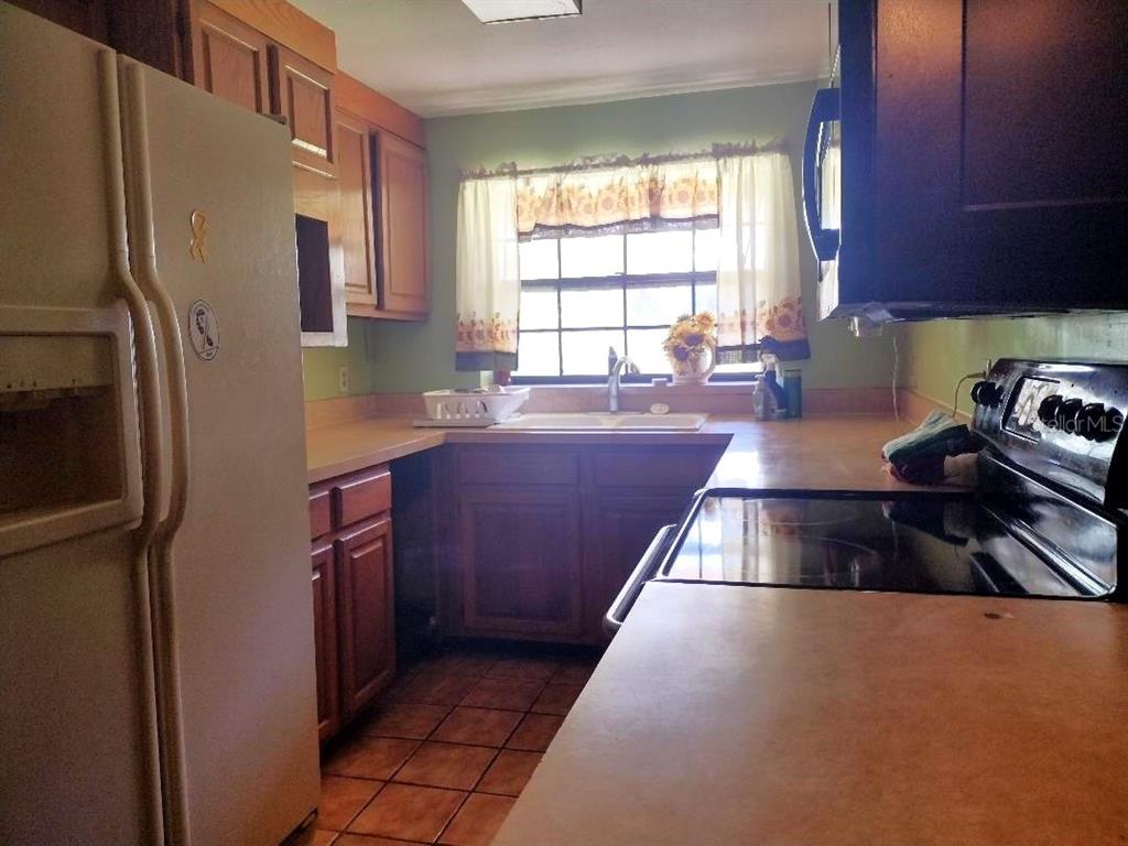 651 Old Haw Creek Road Bunnell, FL 32110 - Photo 11 of 28 a kitchen with granite countertop a refrigerator and a stove top oven