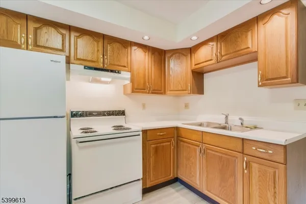 a kitchen with a sink a refrigerator and cabinets