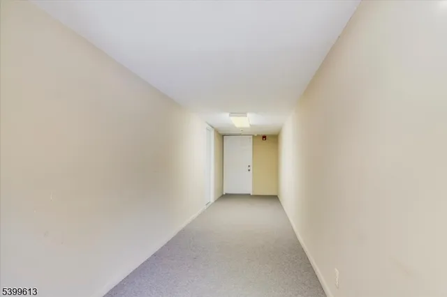 a view of a hallway with wooden floor and a window