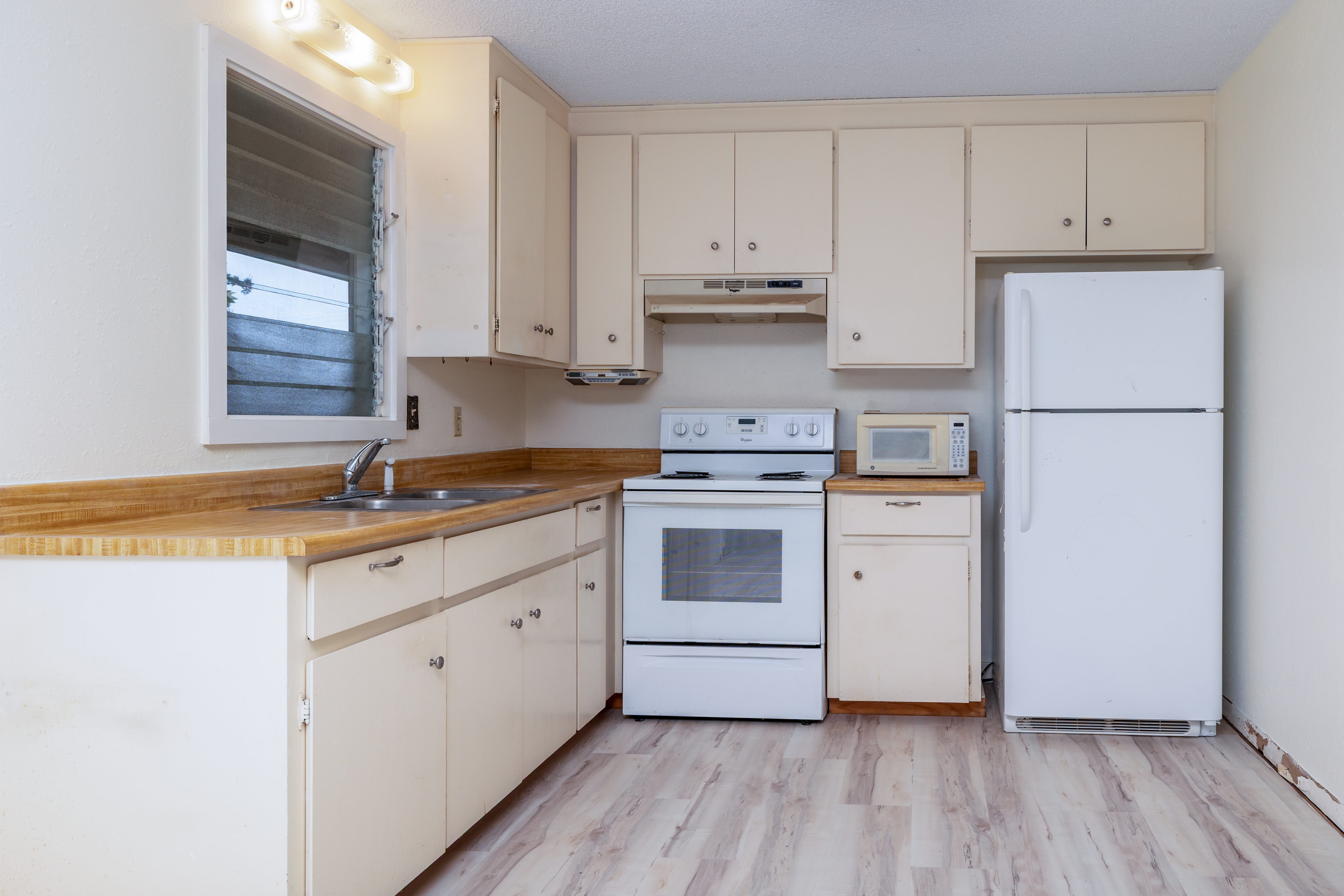 75-185-b Alakai Street, Unit B Kailua-Kona, HI 96740 - Photo 18 of 27 a kitchen with a white cabinets and white appliances