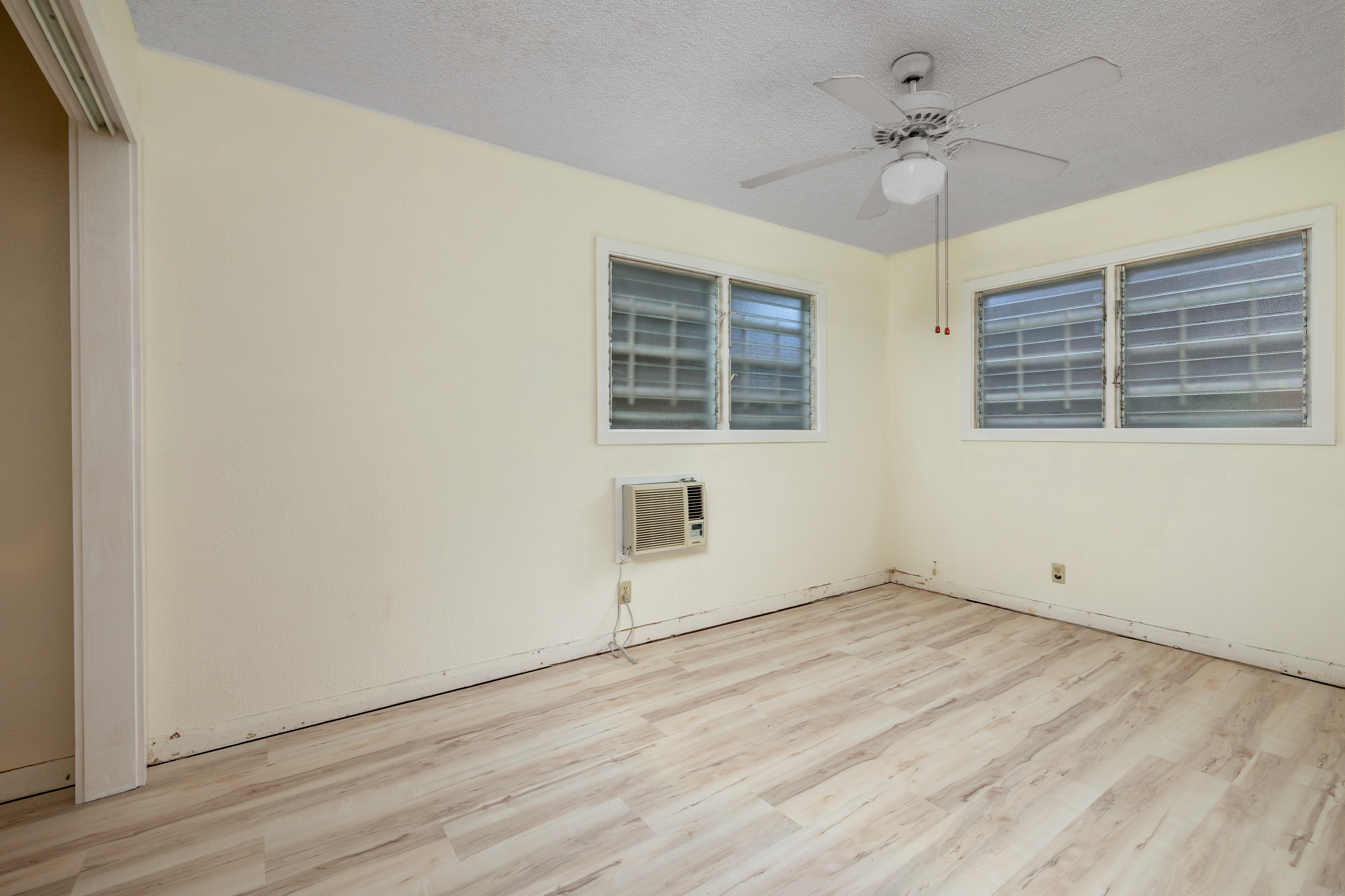 75-185-b Alakai Street, Unit B Kailua-Kona, HI 96740 - Photo 9 of 27 an empty room with wooden floor and windows