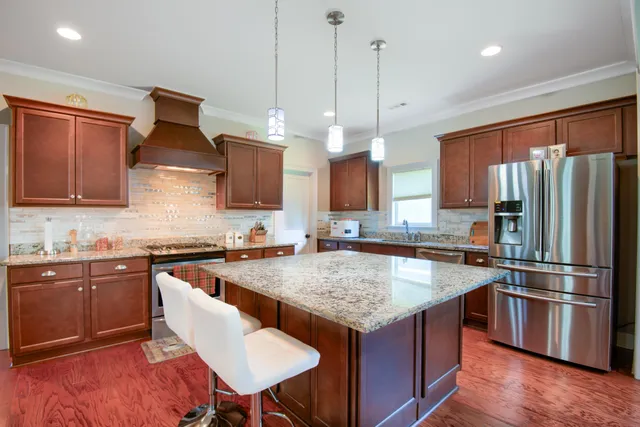 a kitchen with stainless steel appliances granite countertop a sink stove and refrigerator