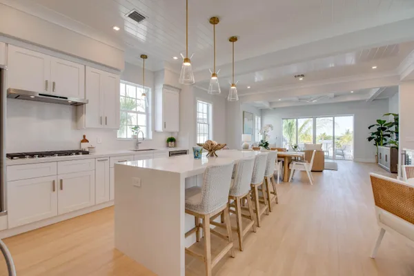a kitchen with kitchen island white cabinets and stainless steel appliances