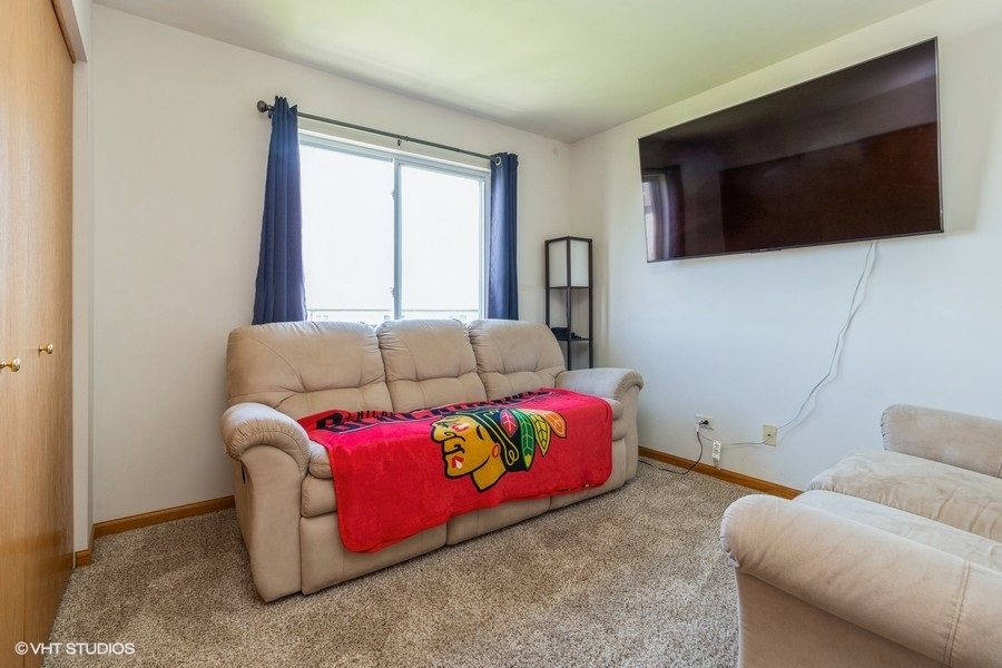 1504 Kempton Street Joliet, IL 60431 - Photo 11 of 15 a living room with furniture and a flat screen tv