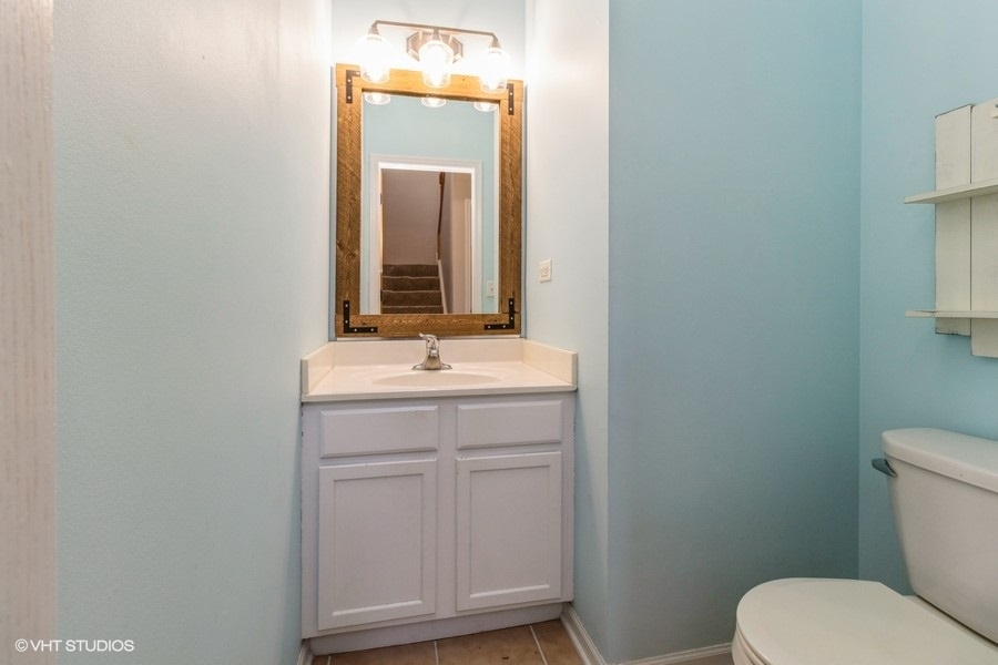 1504 Kempton Street Joliet, IL 60431 - Photo 13 of 15 a bathroom with a toilet sink and mirror