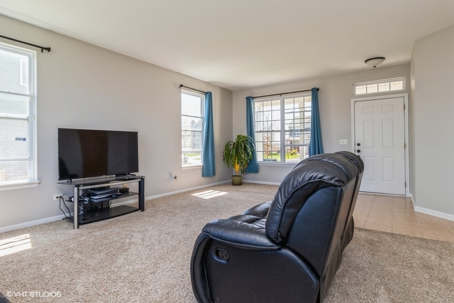 1504 Kempton Street Joliet, IL 60431 - Photo 2 of 15 a living room with furniture and a flat screen tv