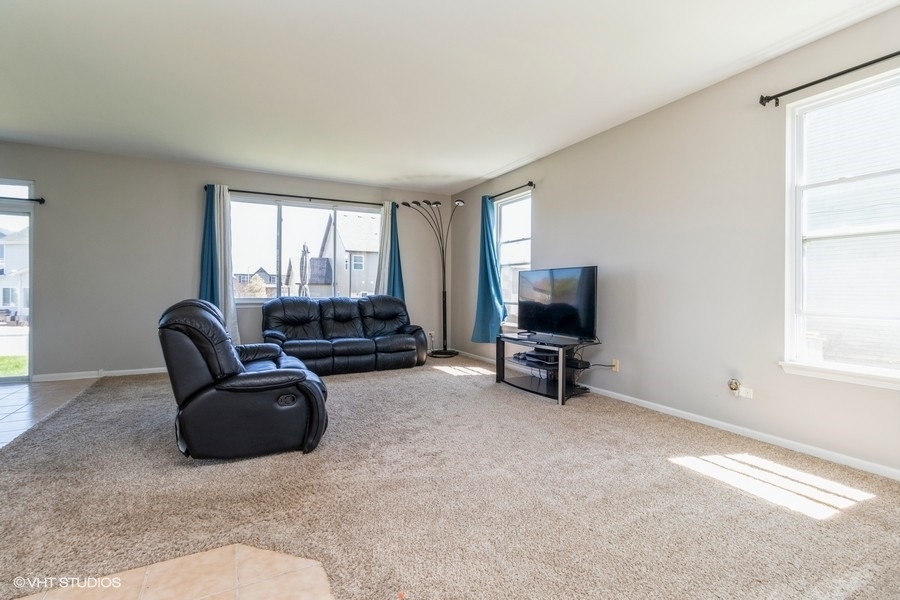 1504 Kempton Street Joliet, IL 60431 - Photo 3 of 15 a living room with furniture and a flat screen tv