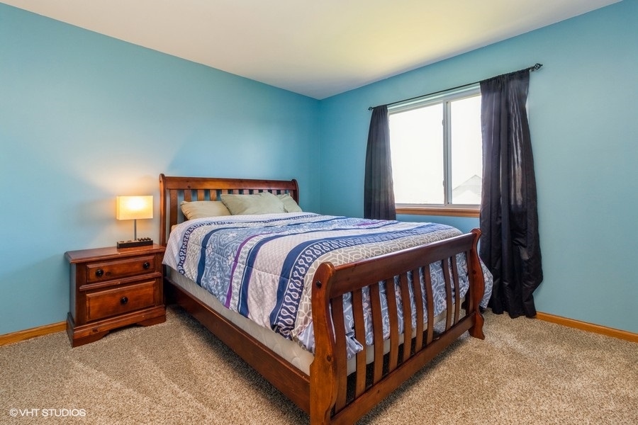 1504 Kempton Street Joliet, IL 60431 - Photo 9 of 15 a bed sitting in a bedroom next to a window