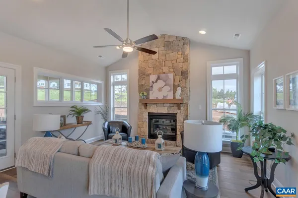 a living room with furniture a fireplace and a potted plant