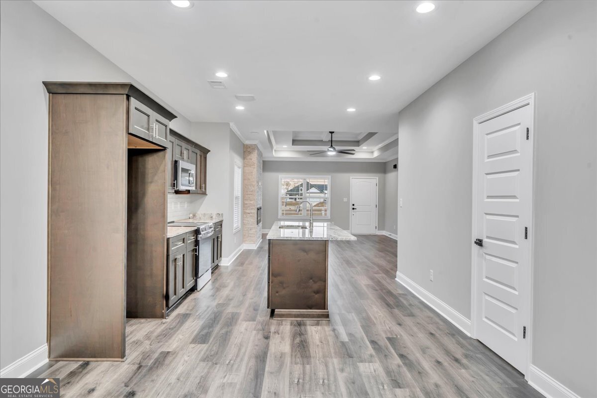 212 Eric Court Byron, GA 31008 - Photo 11 of 37 a view of a hallway with wooden floor and kitchen