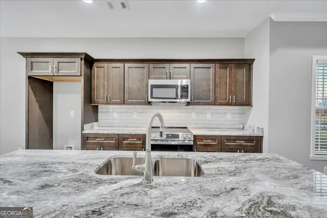 a kitchen with granite countertop a sink and a stove top oven