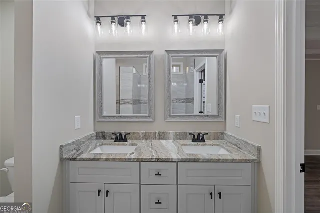 a bathroom with a granite countertop sink and a mirror