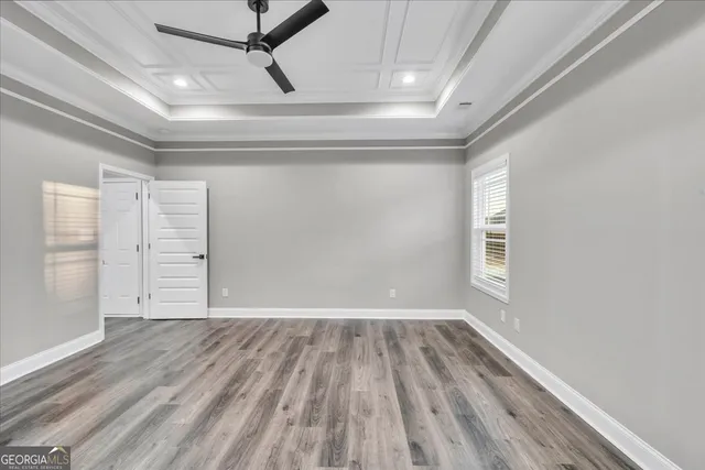 a view of an empty room with a window and wooden floor