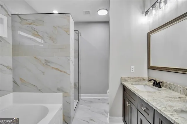 a bathroom with a granite countertop sink a mirror and a bathtub