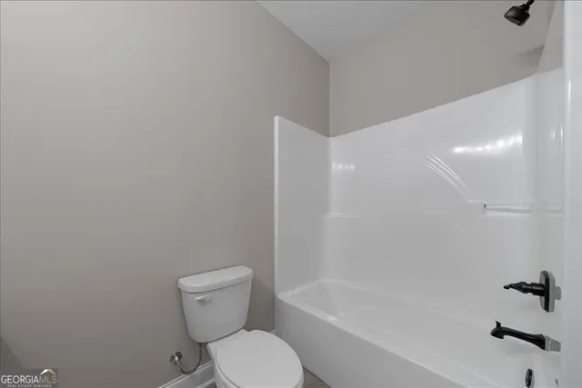 a white toilet sitting next to a bath tub