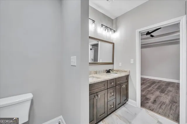 a spacious bathroom with a toilet a sink a mirror and a bathtub