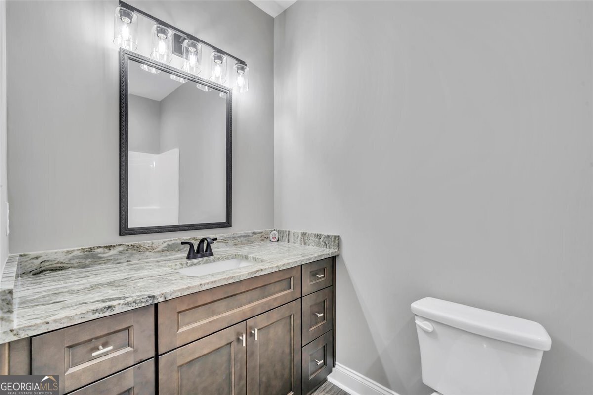 212 Eric Court Byron, GA 31008 - Photo 30 of 37 a bathroom with a granite countertop sink mirror and toilet