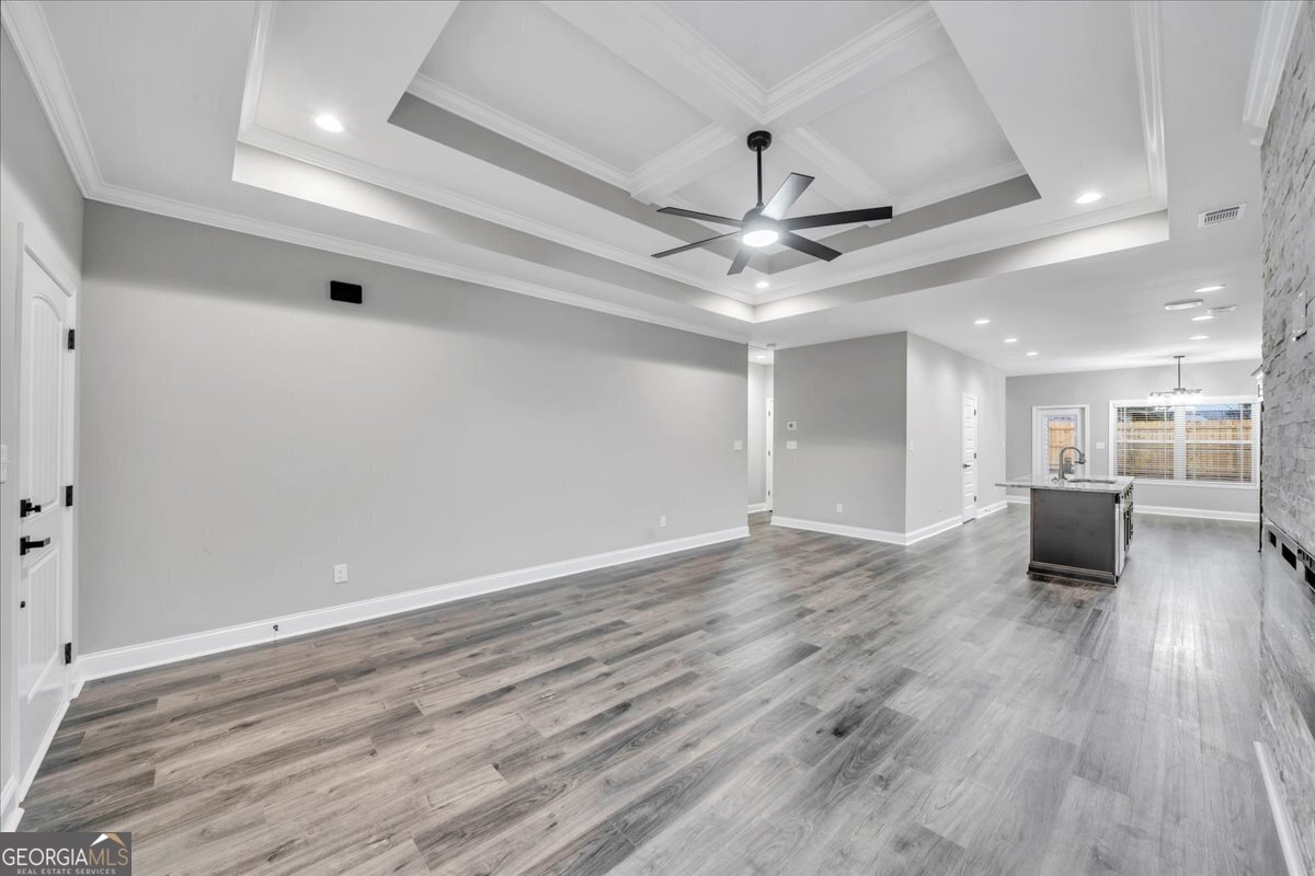 212 Eric Court Byron, GA 31008 - Photo 4 of 37 an empty room with wooden floor and a ceiling fan