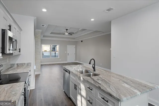 a kitchen with a sink cabinets and wooden floor