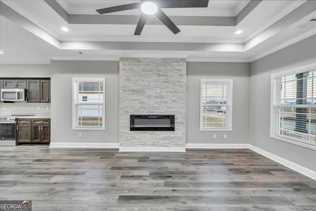 a view of an empty room with a fireplace and a window