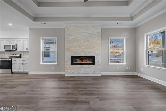 a view of an empty room with window and wooden floor