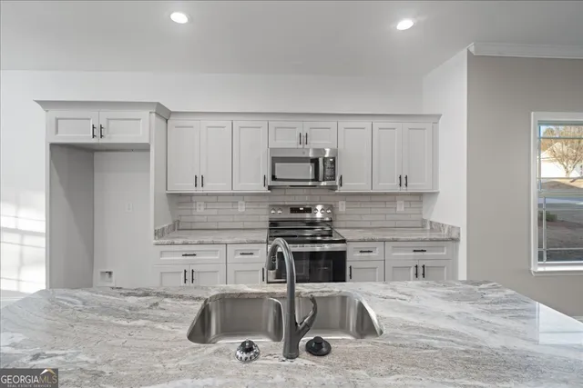 a kitchen with a sink a stove and cabinets