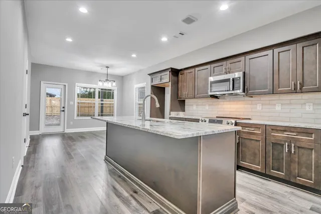 a kitchen with stainless steel appliances granite countertop a sink stove and microwave
