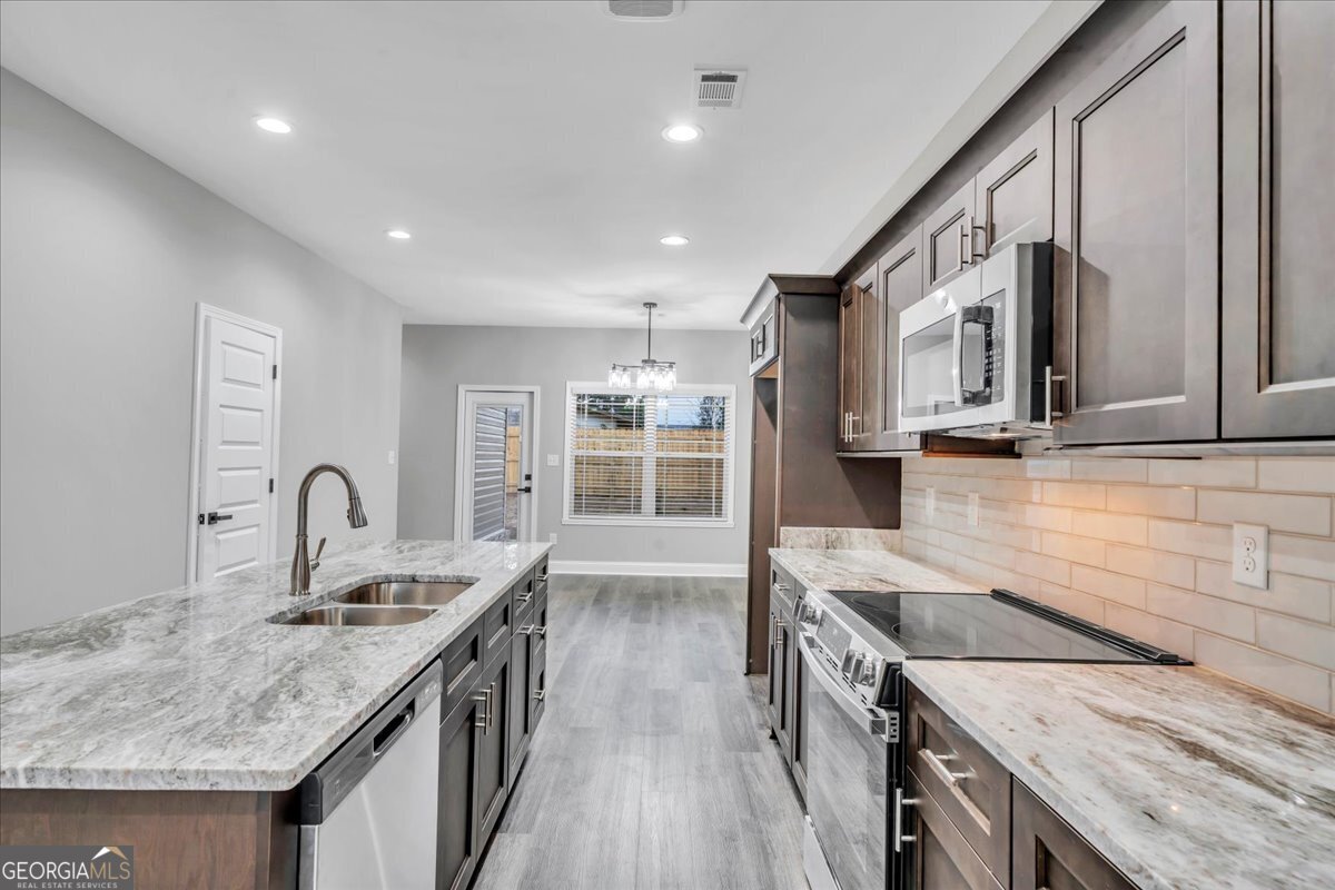 212 Eric Court Byron, GA 31008 - Photo 9 of 37 a kitchen with granite countertop a stove and a sink