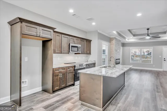 a kitchen with stainless steel appliances granite countertop a sink stove and refrigerator