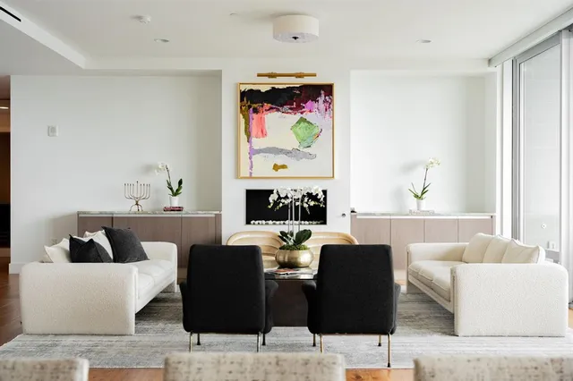 a living room with couches a coffee table and painting on the wall