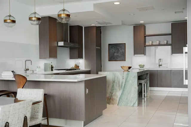 a kitchen with furniture a sink a window and stainless steel appliances