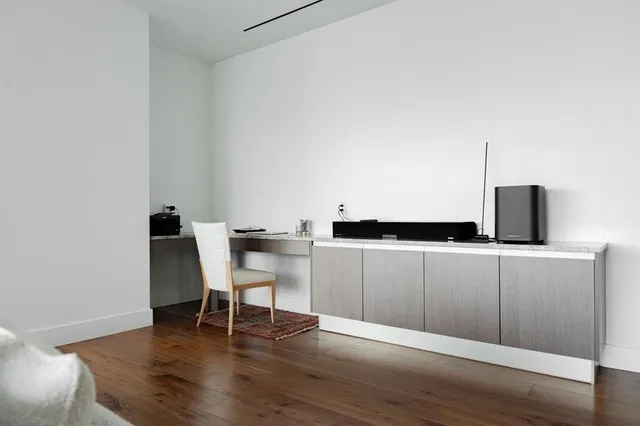 a view of a workspace with furniture and wooden floor
