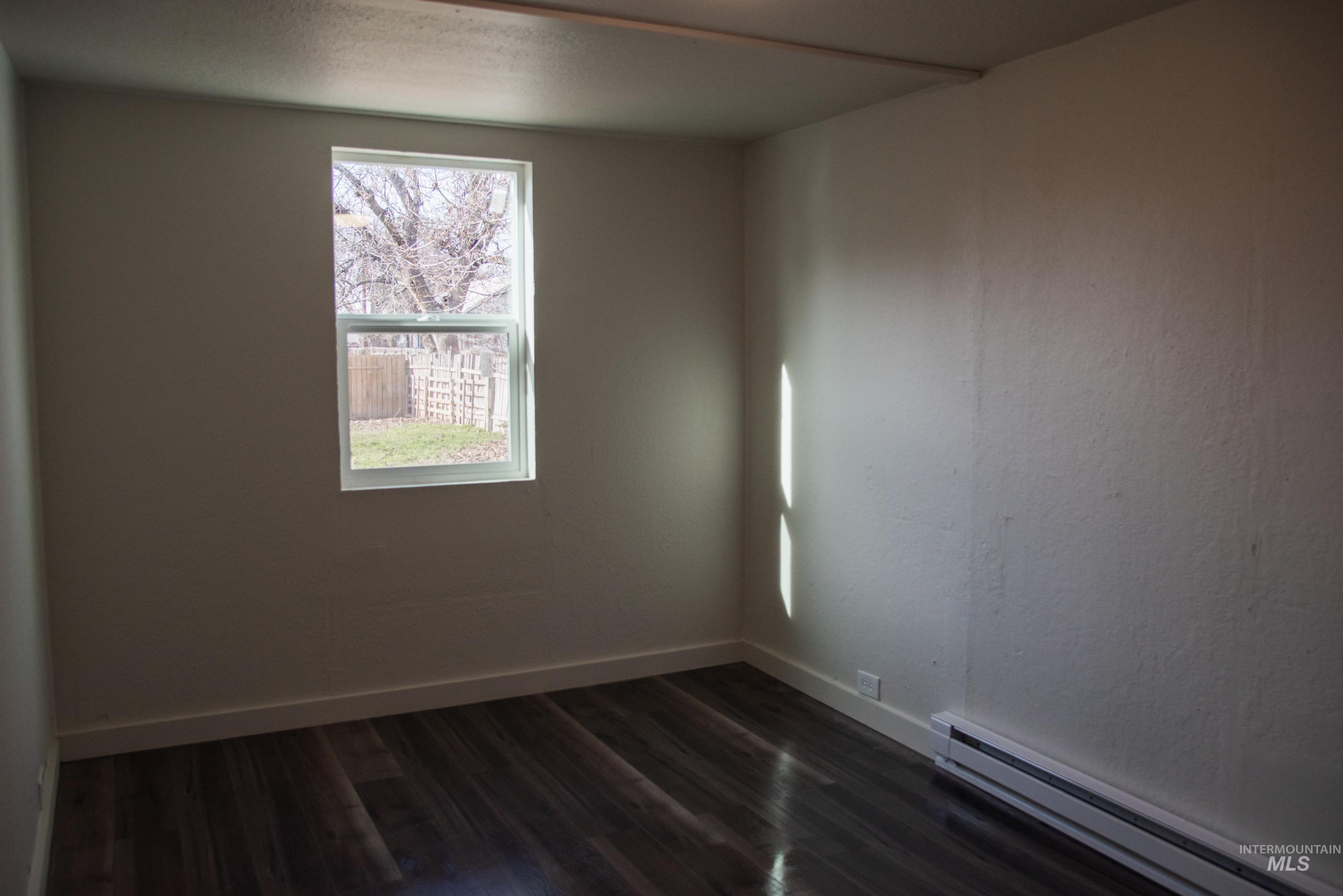 907 North 7th Street Payette, ID 83661 - Photo 12 of 15 Spare room with a baseboard radiator and dark wood-style floors