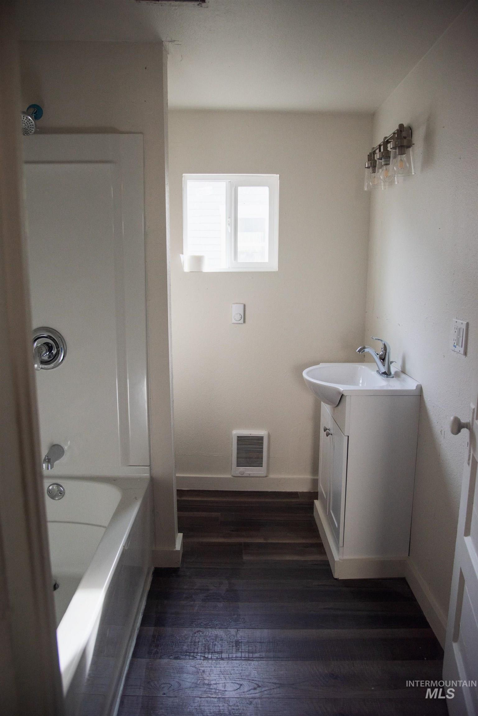 907 North 7th Street Payette, ID 83661 - Photo 9 of 15 Full bath with vanity, dark wood-type flooring, and shower / bath combination