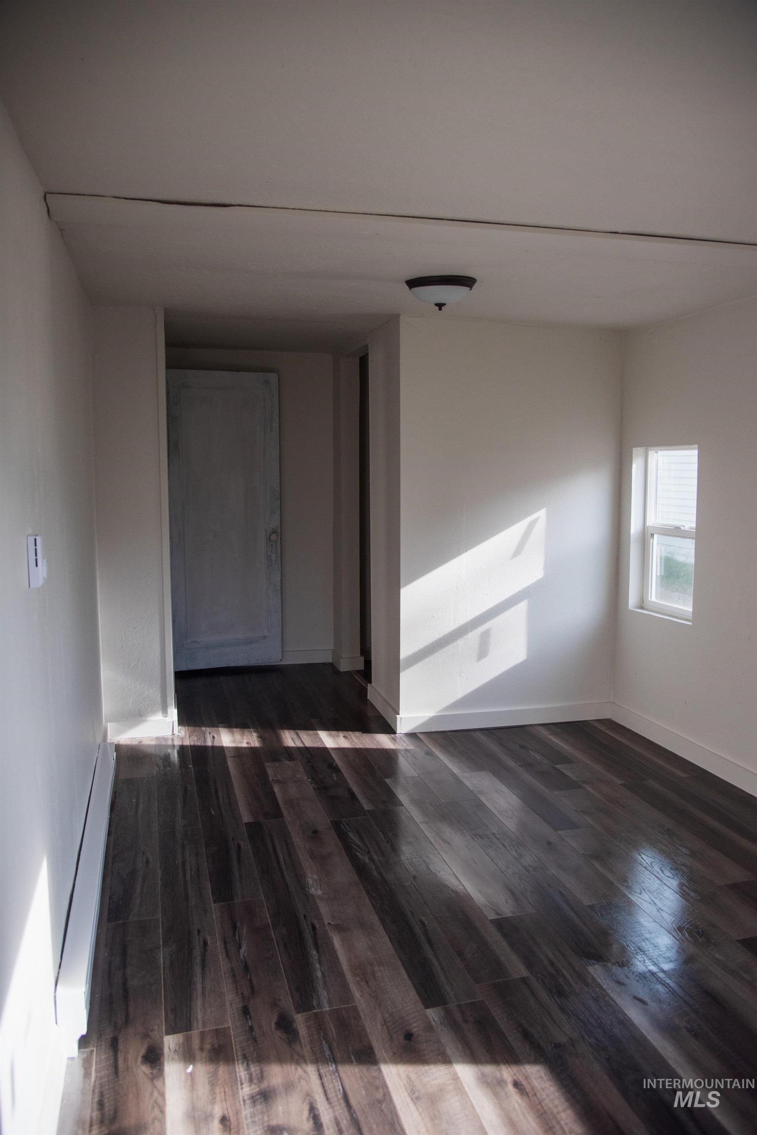 907 North 7th Street Payette, ID 83661 - Photo 10 of 15 Unfurnished room with dark wood finished floors and baseboard heating