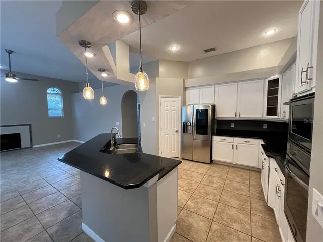 a kitchen with stainless steel appliances granite countertop a sink and a refrigerator