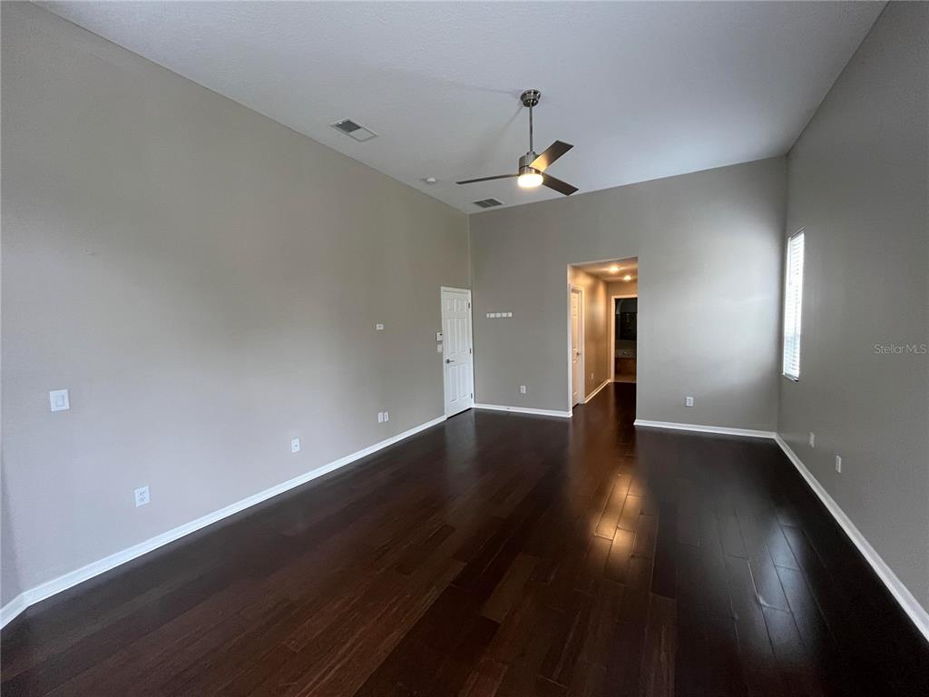 2533 Ridgewind Way Windermere, FL 34786 - Photo 8 of 33 an empty room with wooden floor and ceiling fan