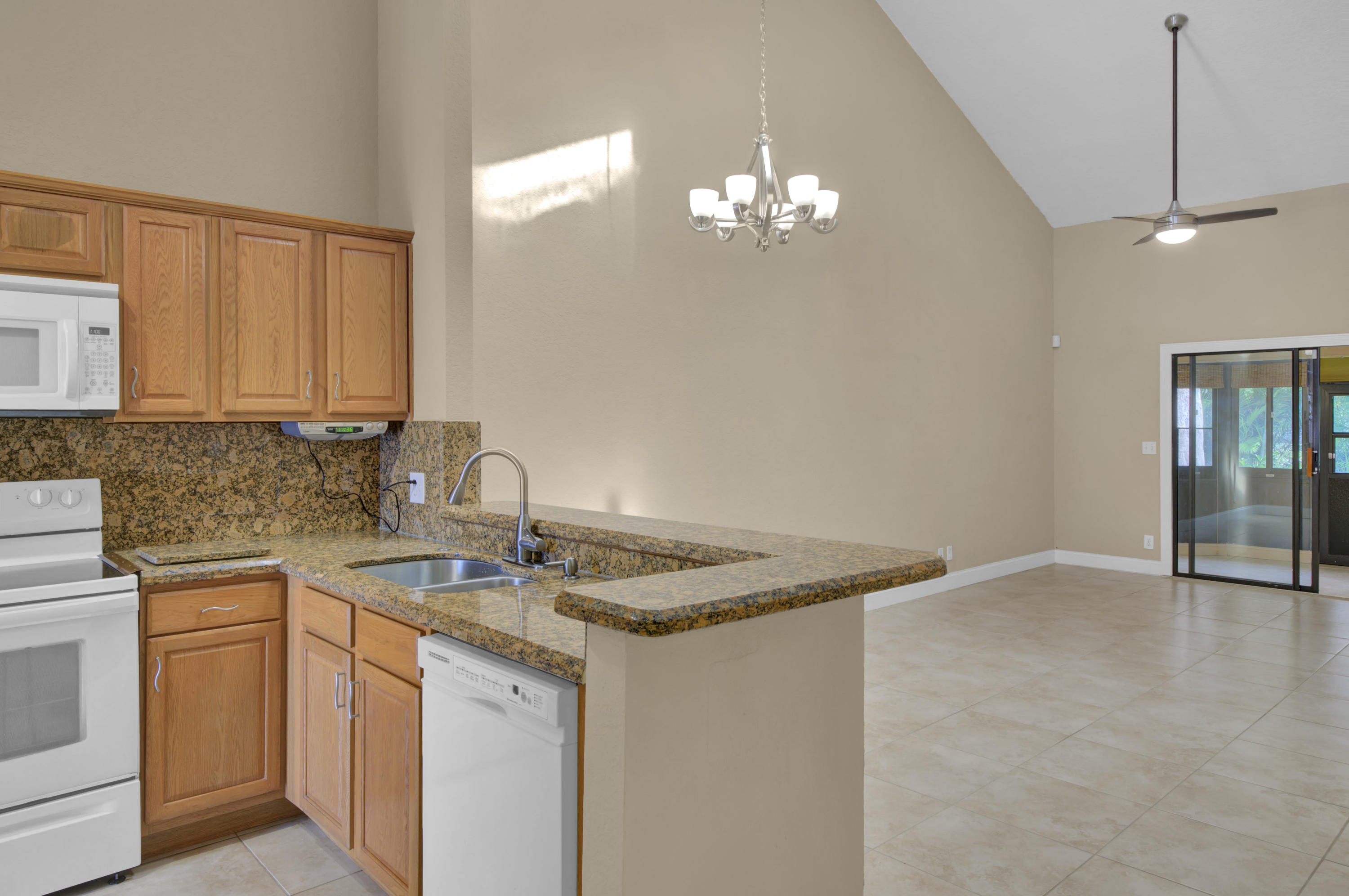 3765 Blue Ridge Road West Palm Beach, FL 33406 - Photo 5 of 15 a kitchen with stainless steel appliances granite countertop a sink dishwasher a stove with wooden cabinets