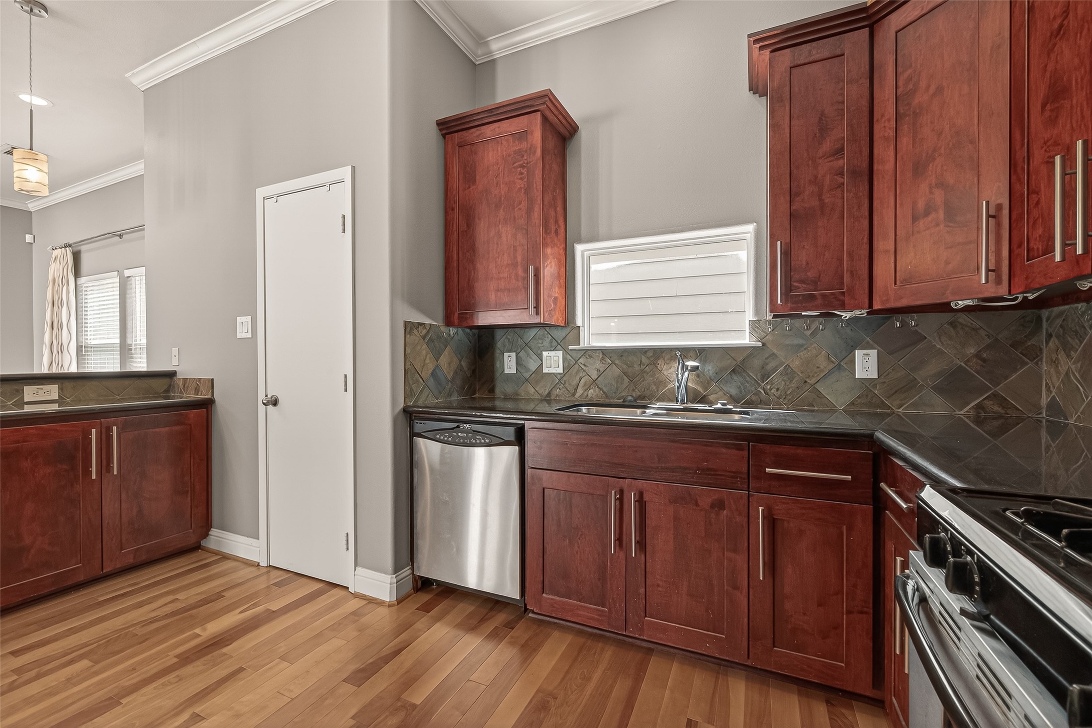 1107 St Charles Street Houston, TX 77003 - Photo 15 of 37 a kitchen with granite countertop wooden cabinets and a stove