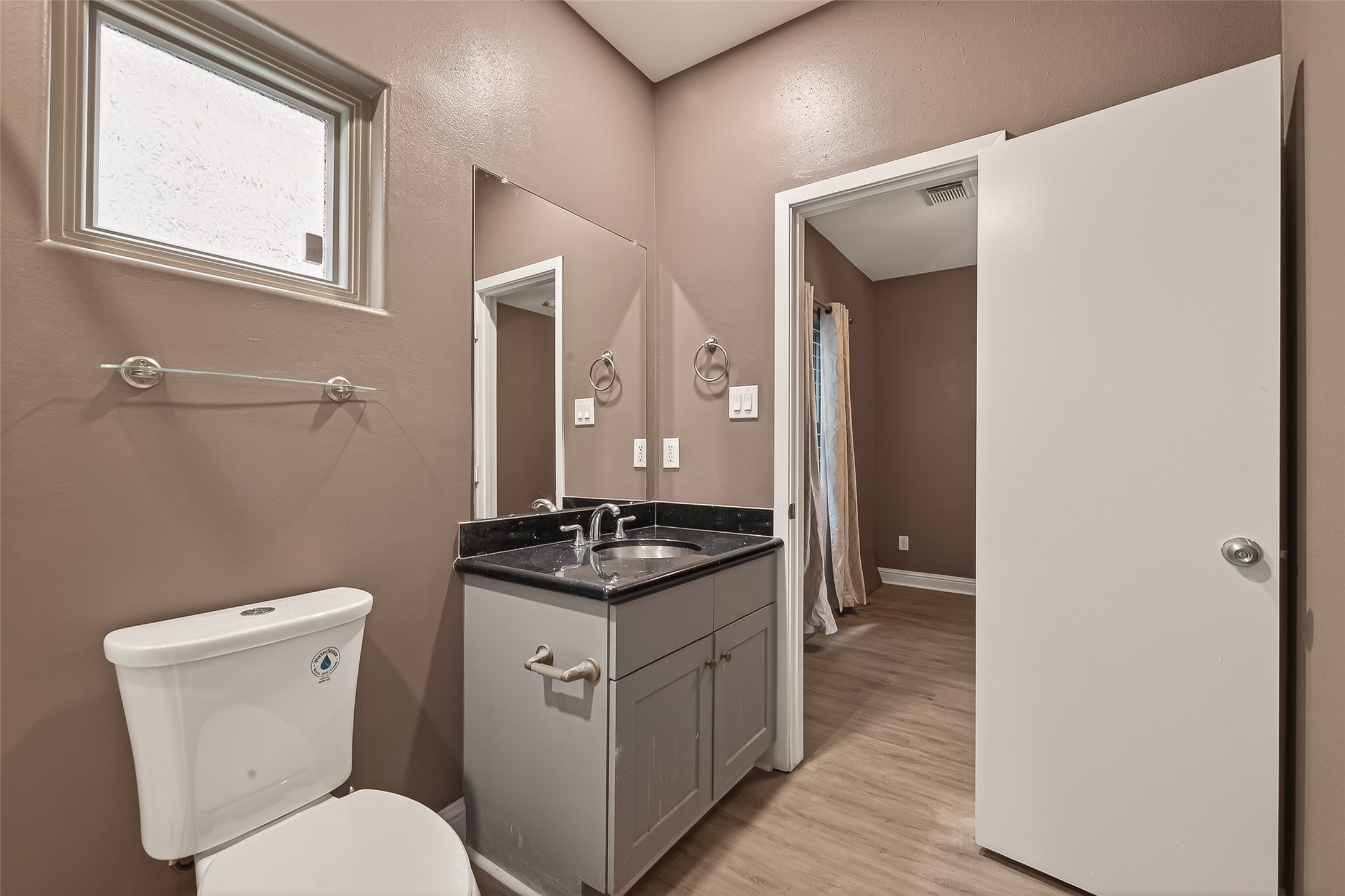 1107 St Charles Street Houston, TX 77003 - Photo 32 of 37 a spacious bathroom with a toilet a sink and mirror