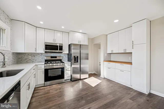 a kitchen with stainless steel appliances granite countertop a stove a sink and a refrigerator